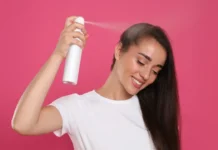 No Time to Wash Your Hair? Here’s How Dry Shampoo Can Save the Day Woman spraying dry shampoo on hair roots for a quick refresh